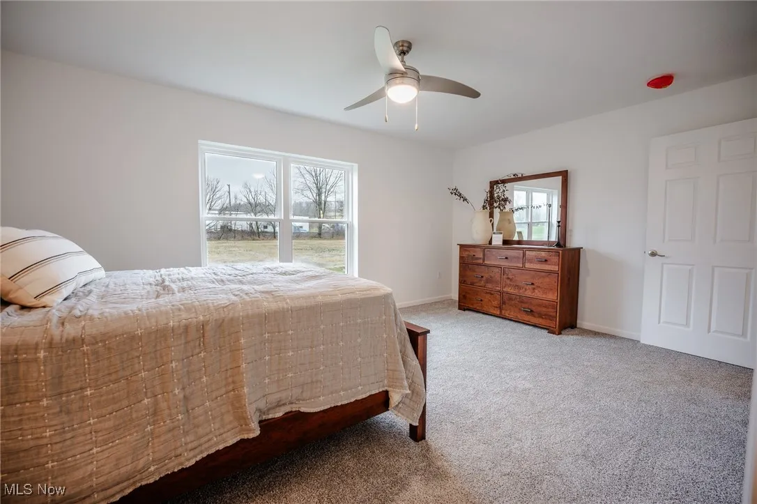 Carpeted bedroom featuring baseboards and a ceiling fan