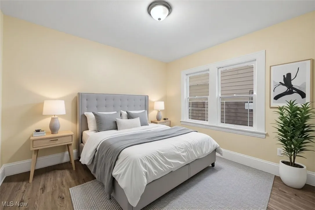 Bedroom with wood finished floors and baseboards
