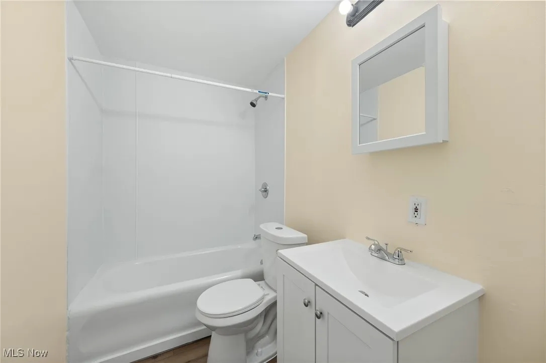 Bathroom with vanity,  shower combination, and wood finished floors