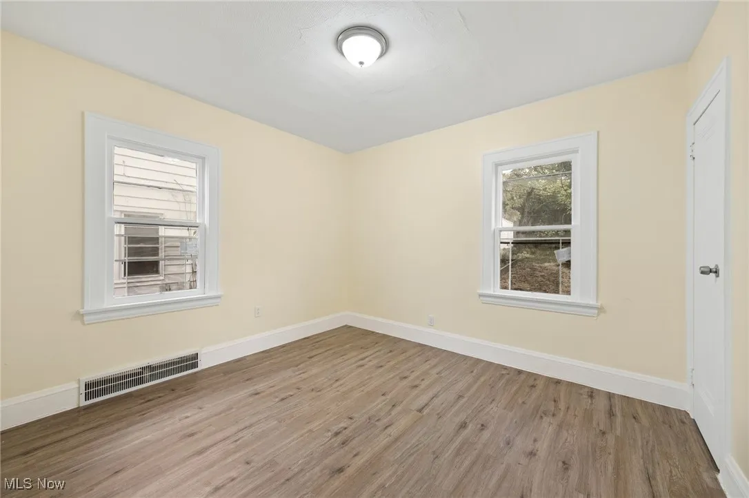 Unfurnished room featuring wood finished floors and baseboards