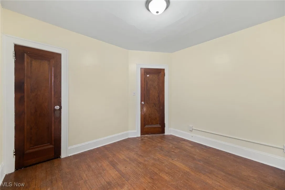 Empty room with dark wood-style flooring and baseboards