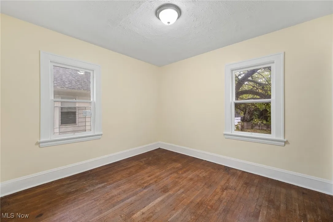 Spare room featuring dark wood-style flooring and a textured ceiling