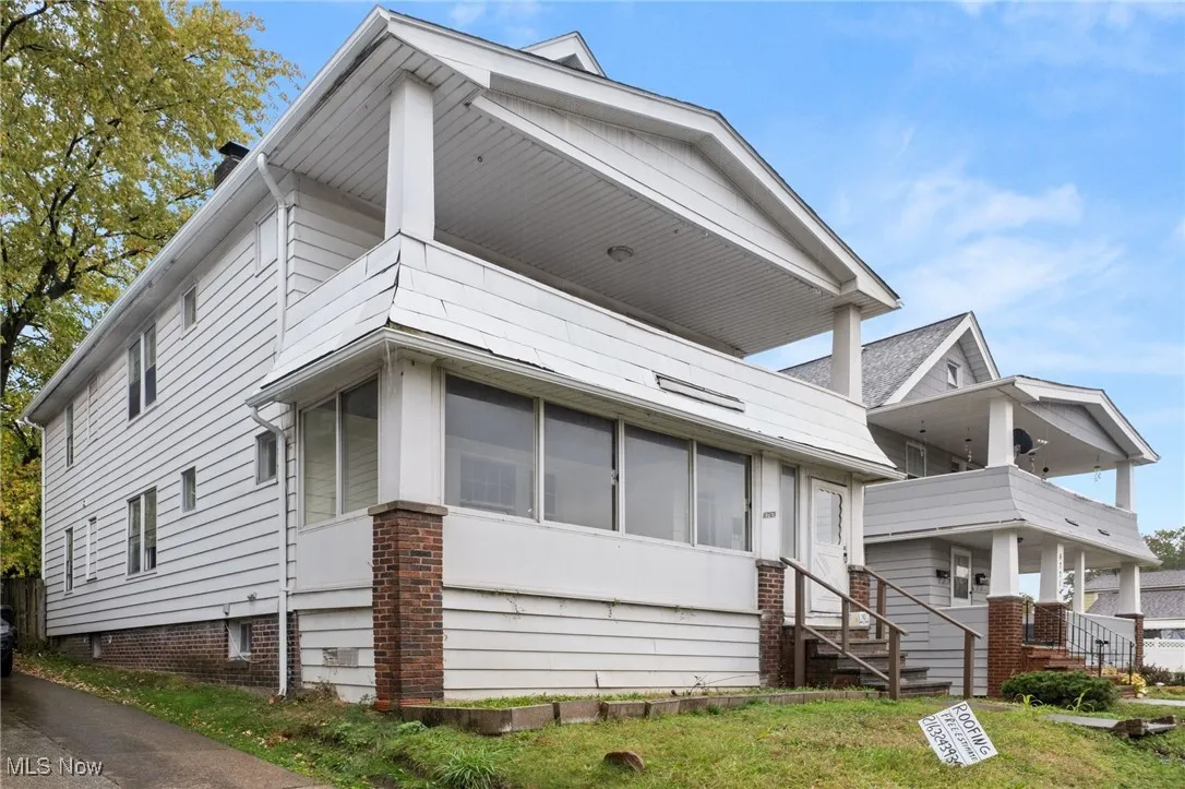 View of front facade featuring a balcony and a sunroom