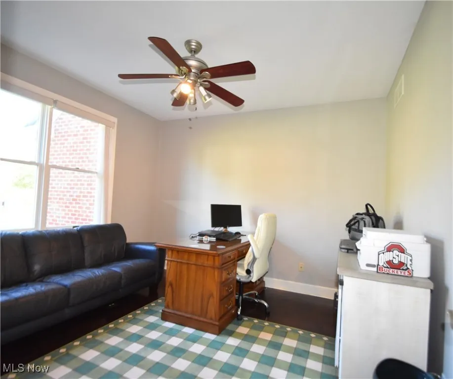 Home office with a ceiling fan and wood finished floors