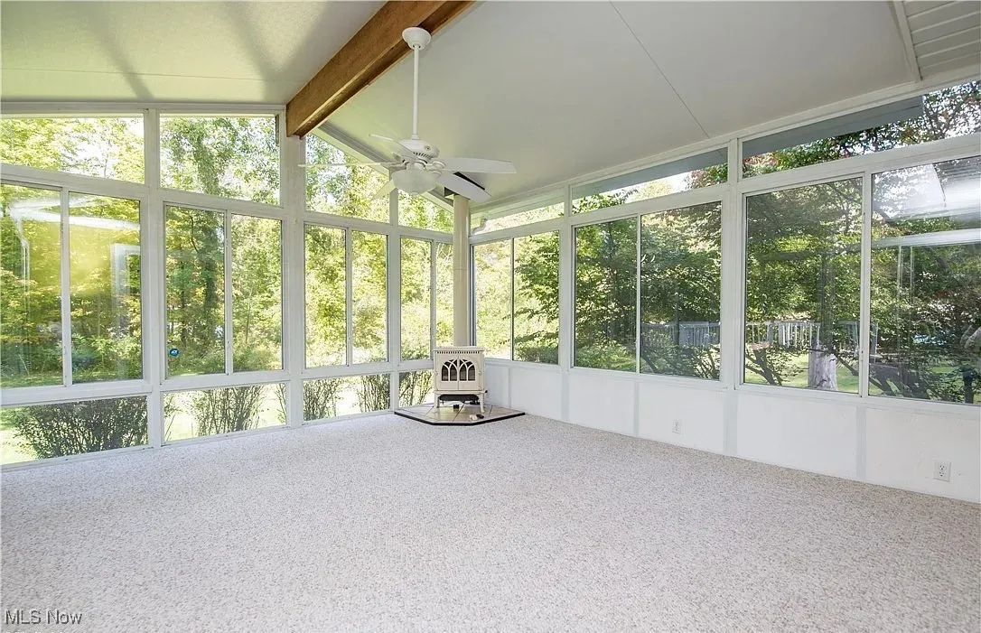 Unfurnished sunroom featuring ceiling fan