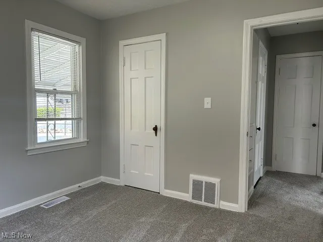 Unfurnished bedroom with baseboards and carpet flooring