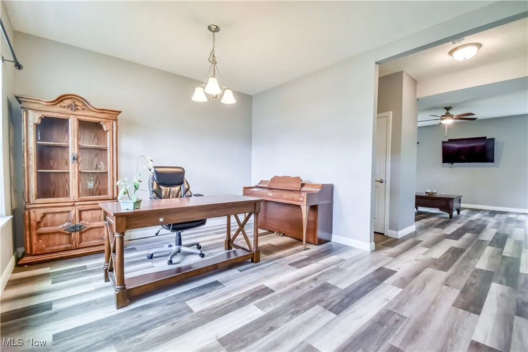 Office with light wood-type flooring and ceiling fan