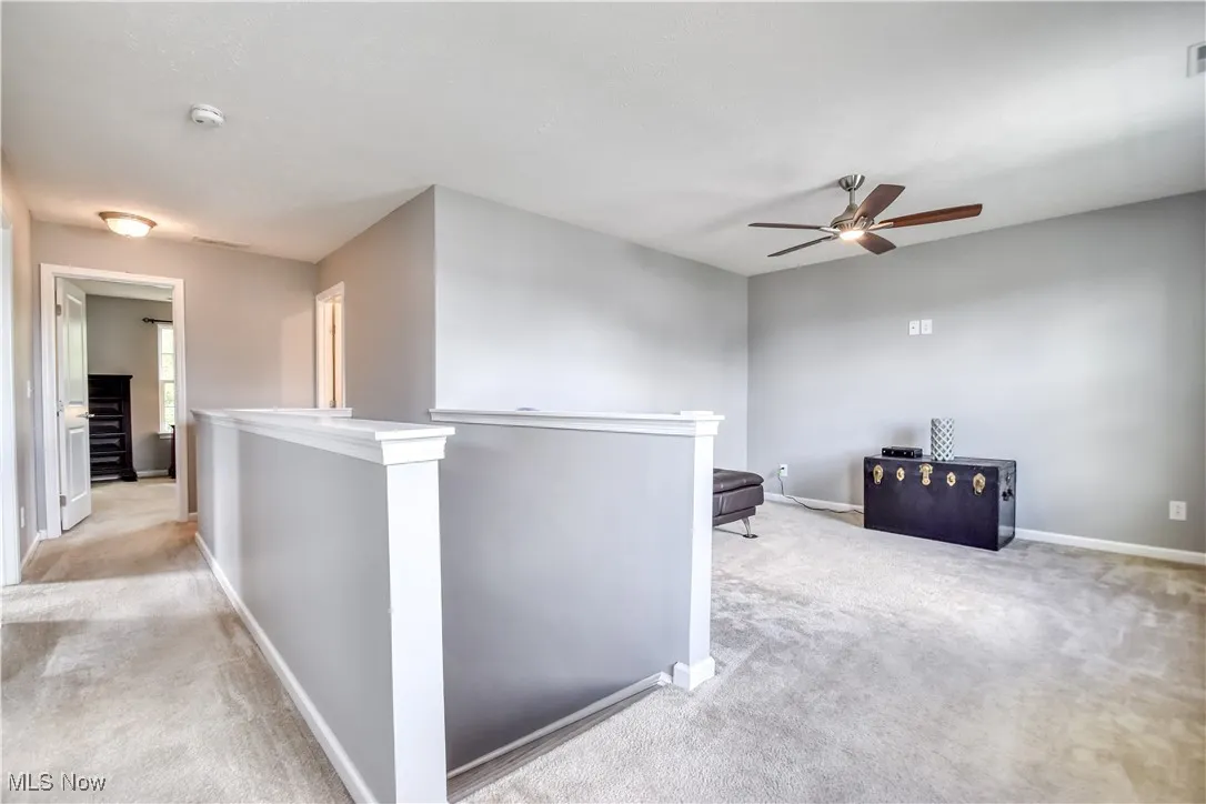 Hall featuring an upstairs landing and light carpet