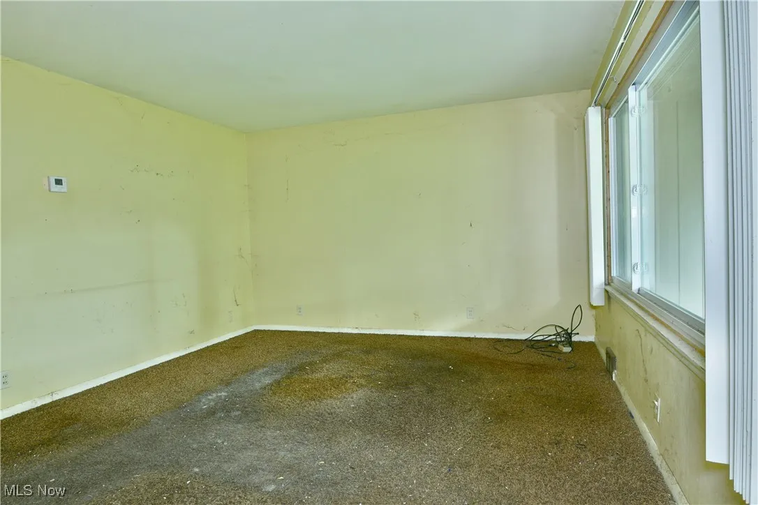 Carpeted empty room with baseboards