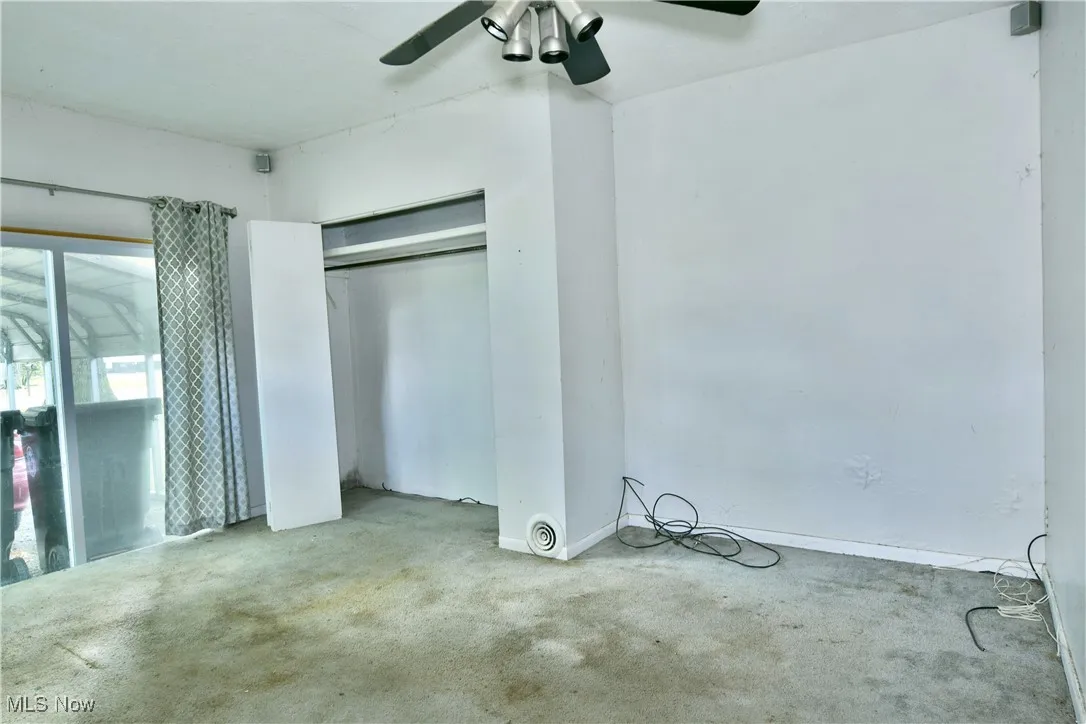 Unfurnished bedroom with carpet, a closet, and a ceiling fan
