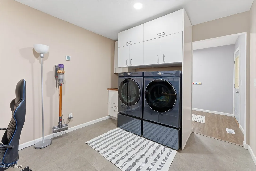 Laundry area with cabinet space and washing machine and clothes dryer