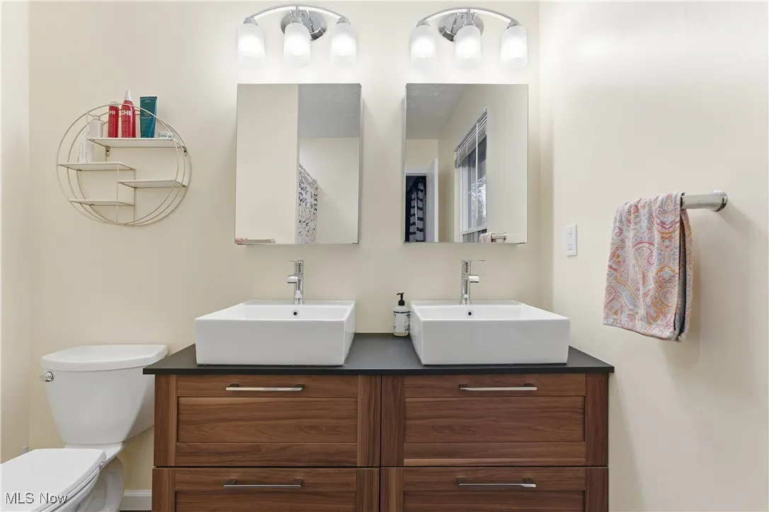 Bathroom featuring double vanity and toilet