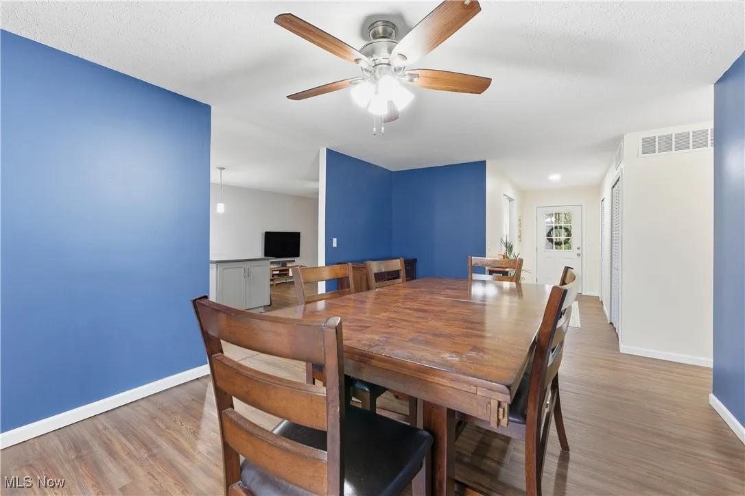 Dining area featuring wood finished floors and a ceiling fan