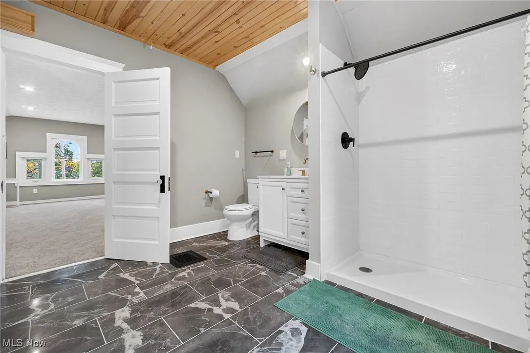 Third floor primary suite featuring a step in shower, tiled floors and a wooden planked ceiling
