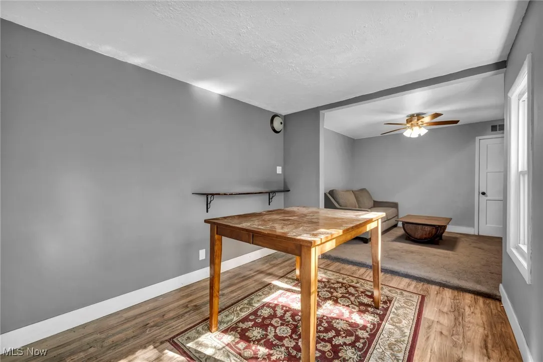 Dining space with wood finished floors, a textured ceiling, and ceiling fan