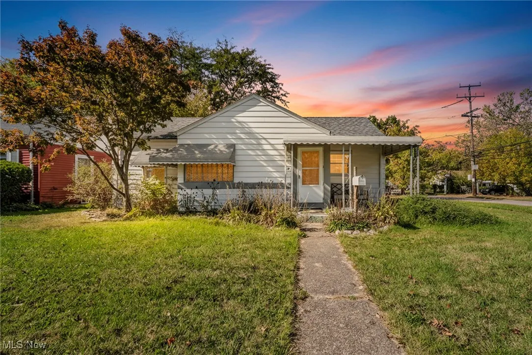 Bungalow-style home featuring a front yard, a porch, and a shingled roof