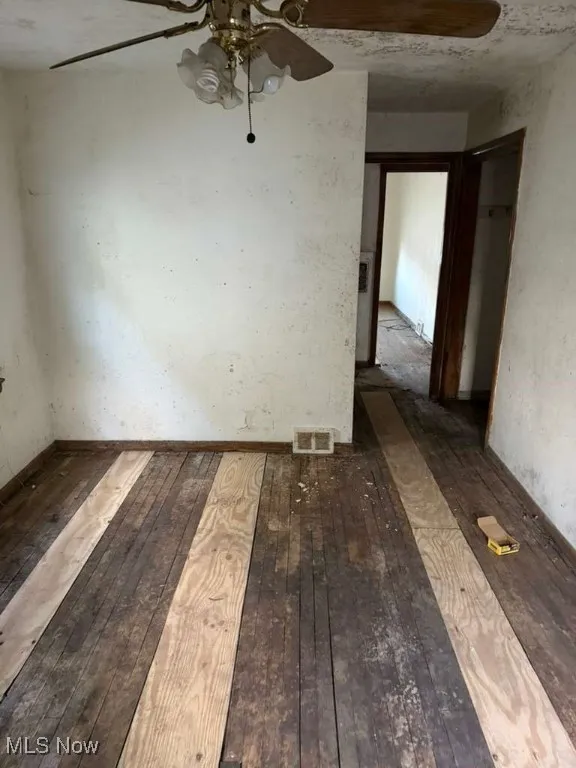 Spare room with hardwood / wood-style floors and ceiling fan