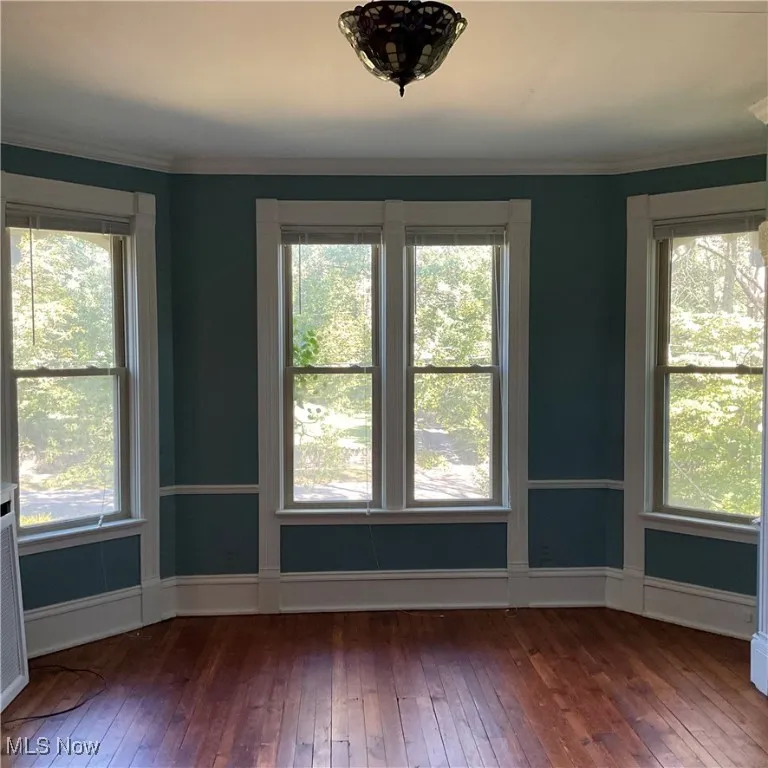Master bedroom on second floor faces east and has wood flooring and ornamental molding