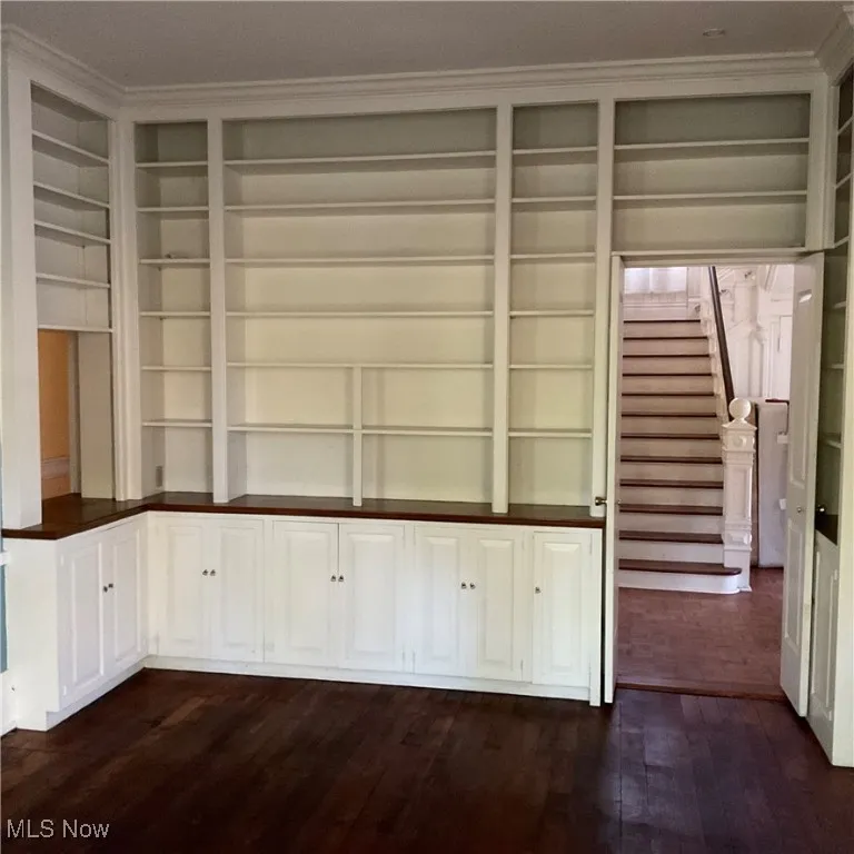 Library with wood floors, shelving and storage.