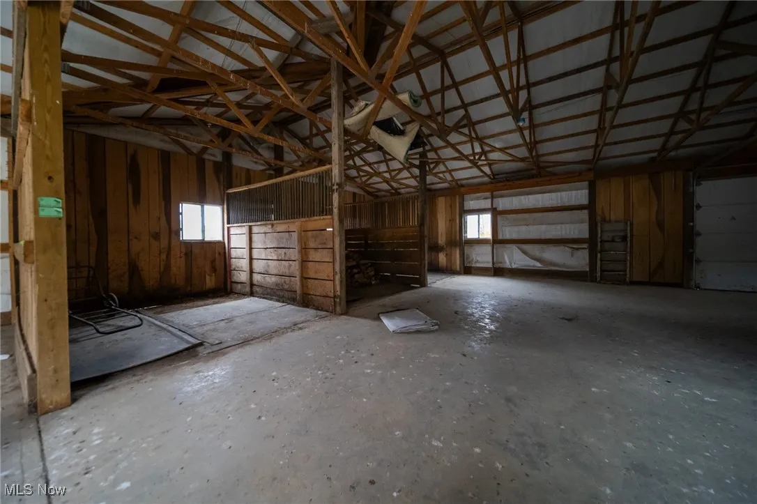 Misc room with vaulted ceiling, metal wall, and a garage