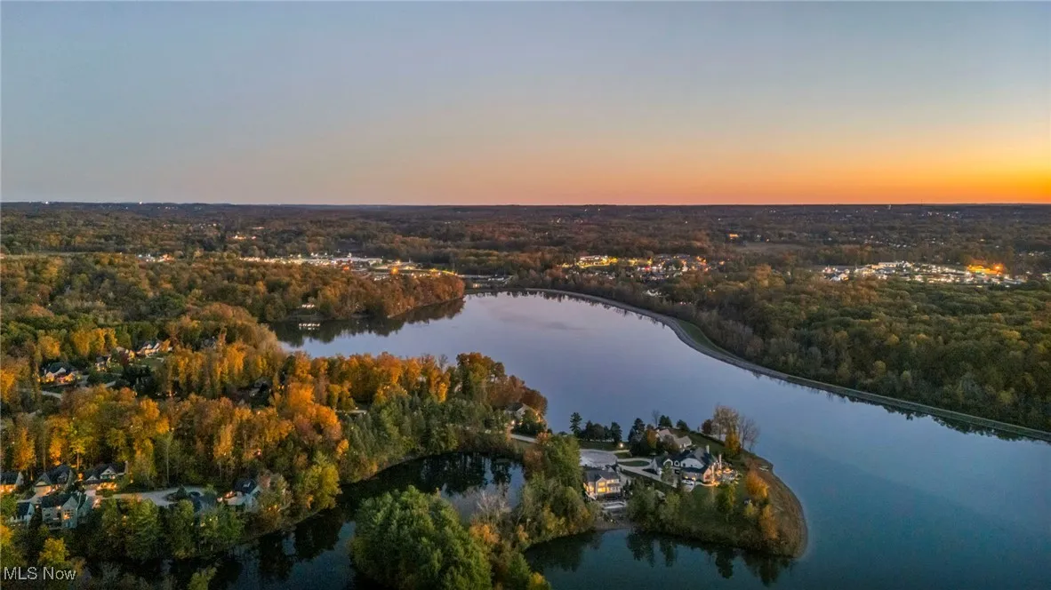 Aerial overview of property's location featuring a large body of water and a heavily wooded area
