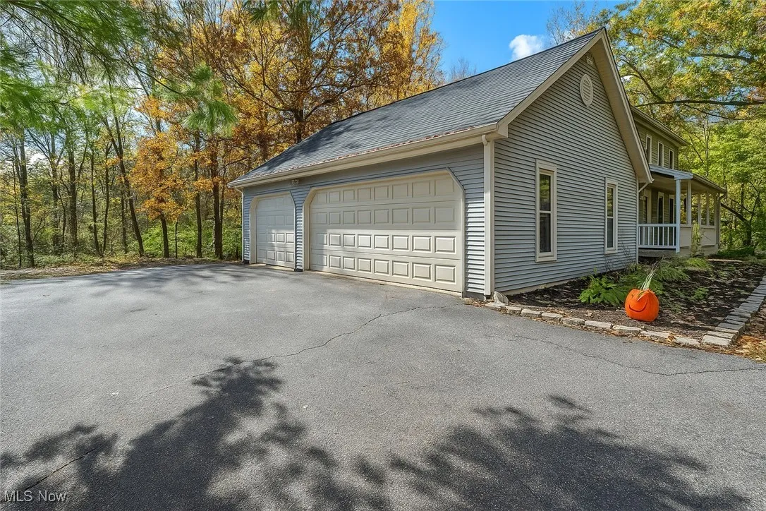 View of home's exterior with a porch and a garage