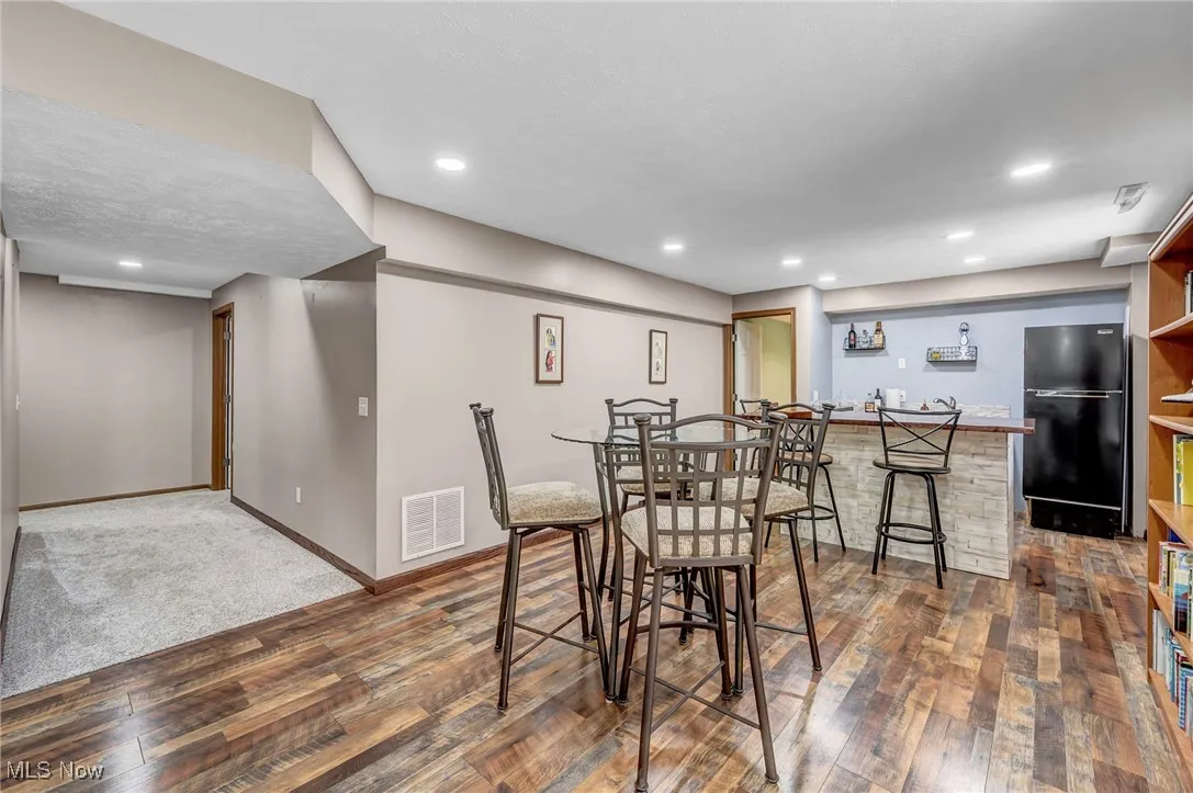 Kitchen with wood counters, plenty of natural light, recessed lighting, a kitchen bar, and dark wood-style flooring