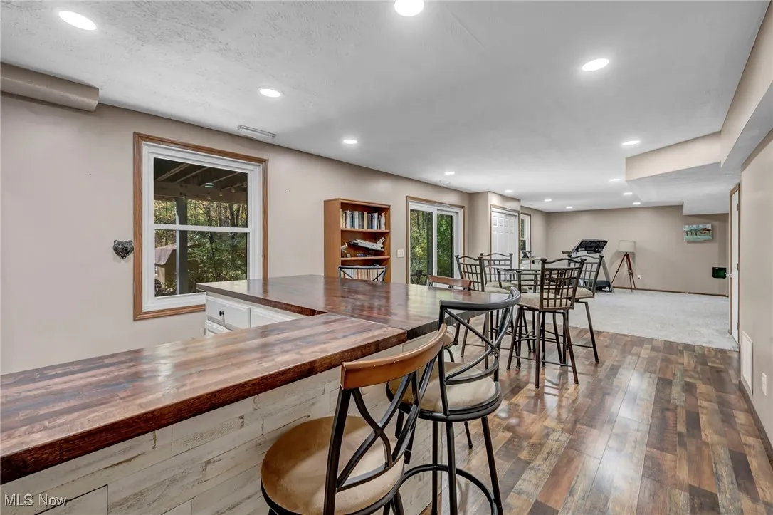Carpeted home office featuring a textured ceiling and baseboards