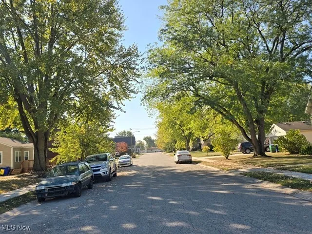 View of asphalt street featuring sidewalks, curbs, and a residential view