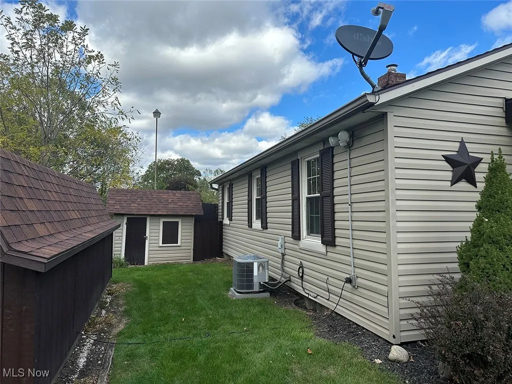 View of home's exterior with a storage unit and a chimney