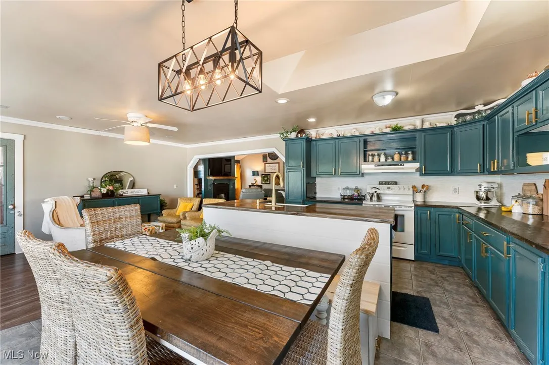 Dining area with arched walkways, recessed lighting, crown molding, a chandelier, and ceiling fan