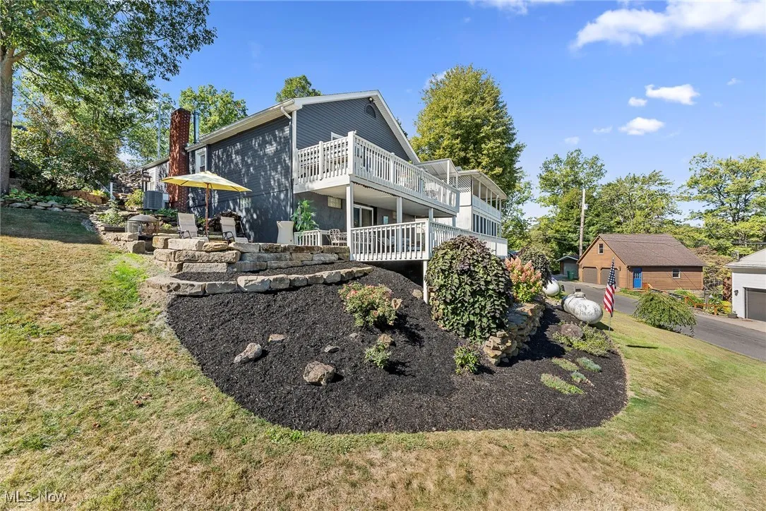 View of side of property with a yard, a chimney, and a patio area