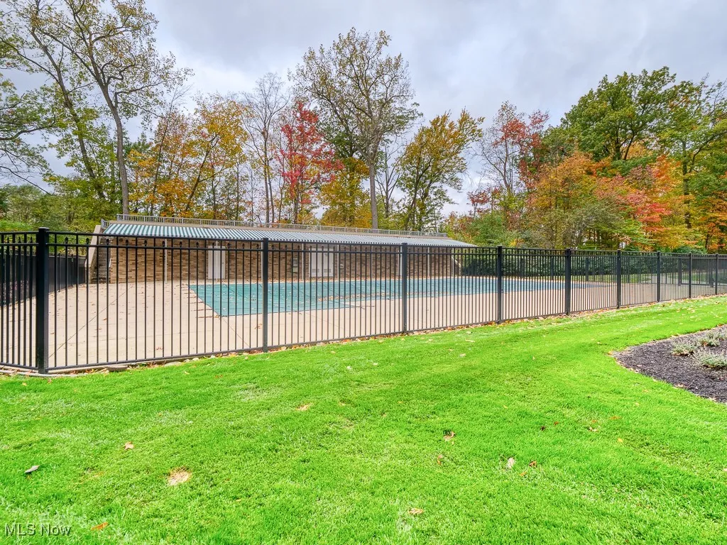 fenced in pool with sunning area