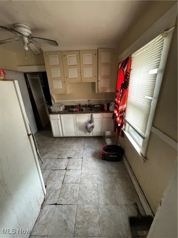 Kitchen featuring refrigerator, white cabinets, a baseboard radiator, dark countertops, and ceiling fan