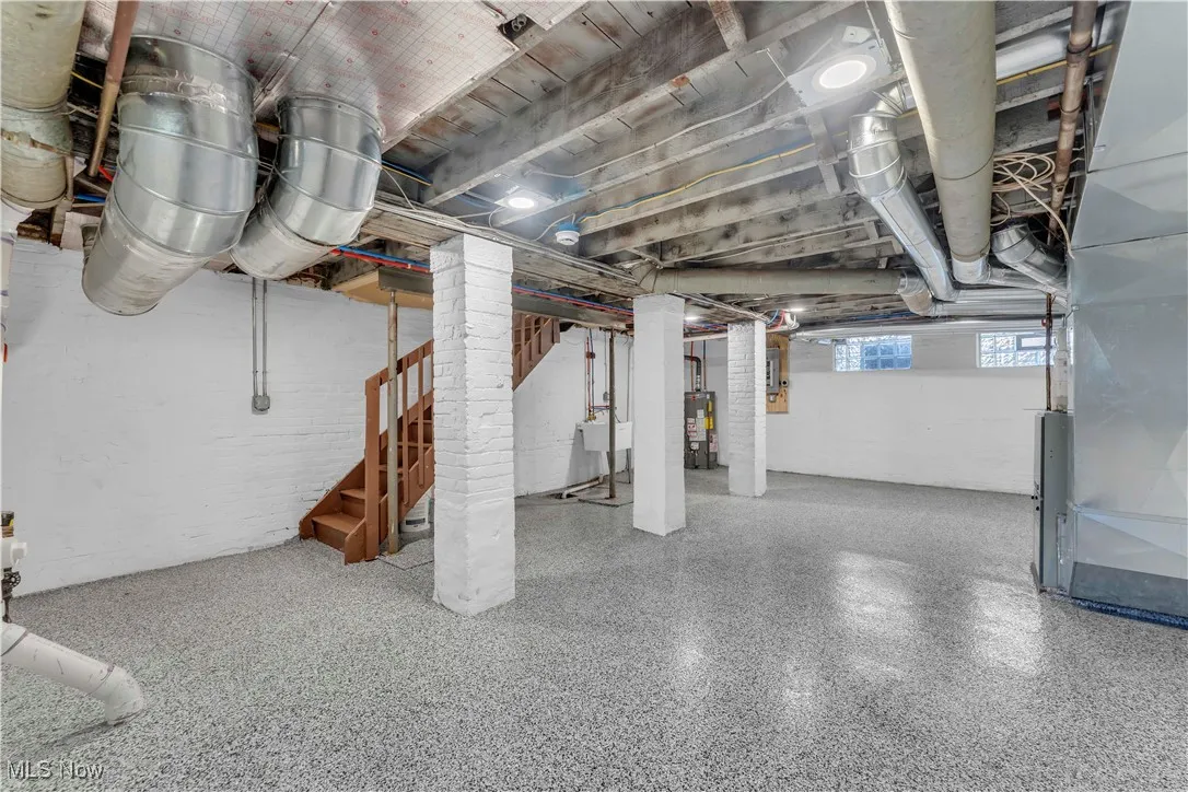 Below grade area featuring stairs and water heater