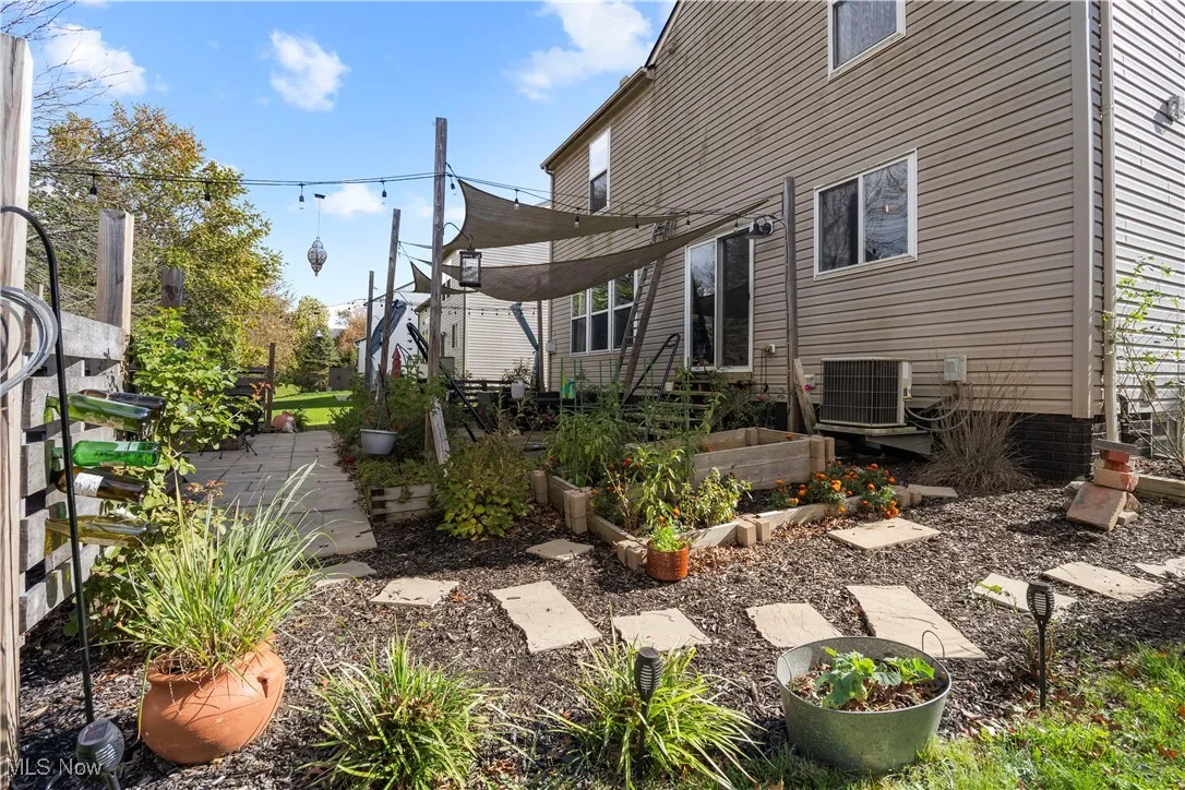 Rear view of house featuring a vegetable garden and a patio