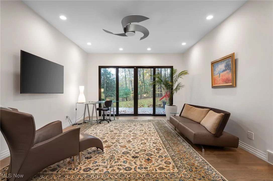 The sitting room offers lounging options and access to the deck and yard.