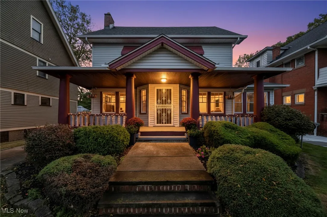 View of front of home with a porch, a chimney, and a shingled roof