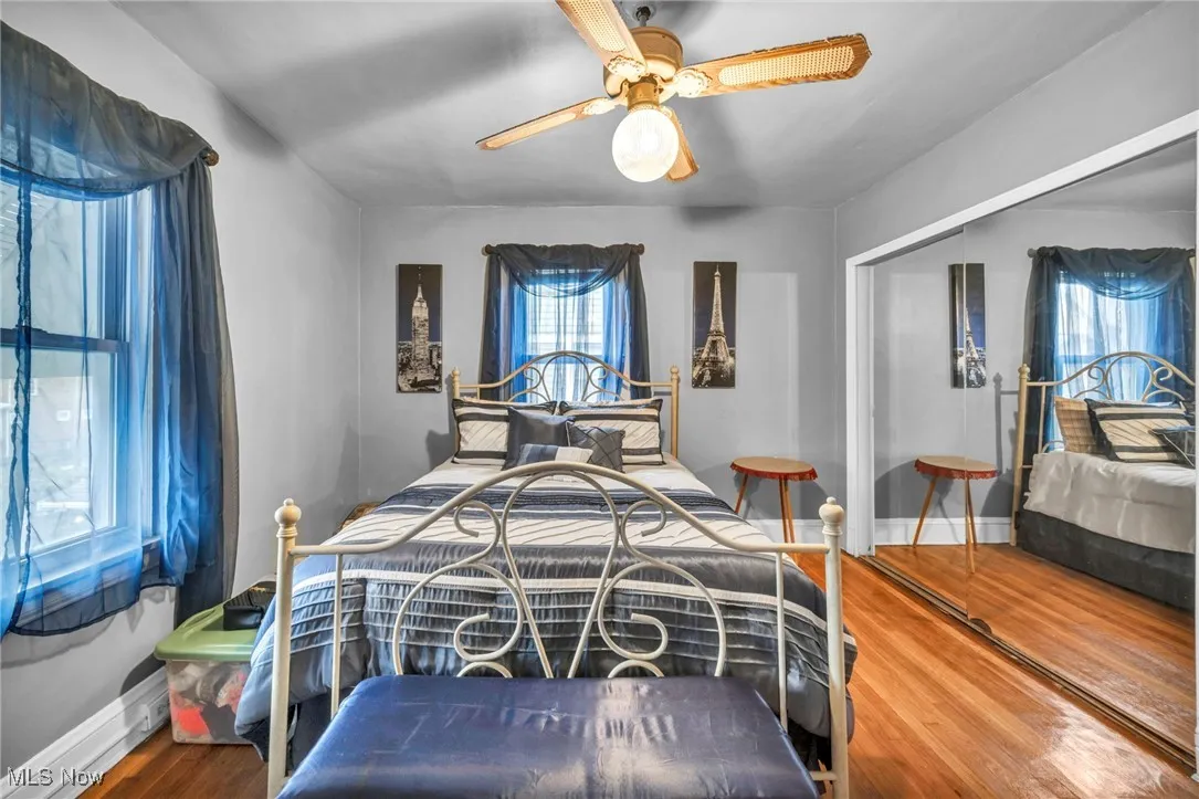 Bedroom with wood finished floors, ceiling fan, and a closet