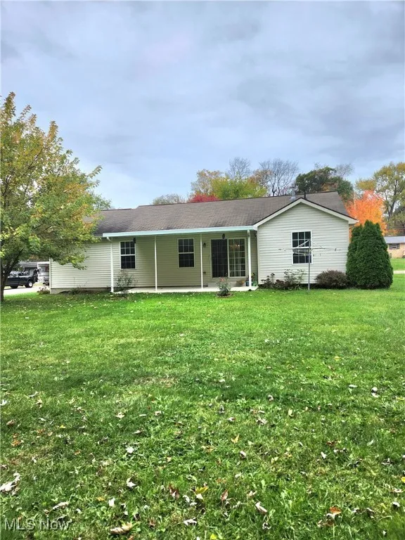 Back of property featuring a lawn