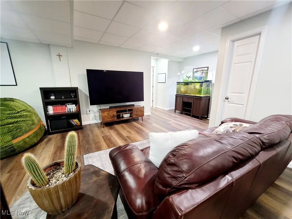 Living room featuring a paneled ceiling and wood finished floors