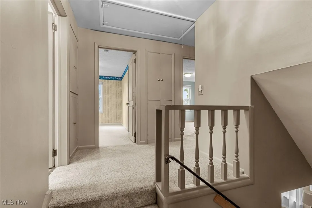 2nd floor hallway features two linen closets, pull down attic with stairs and leads to 4 bedrooms and remodeled main bath
