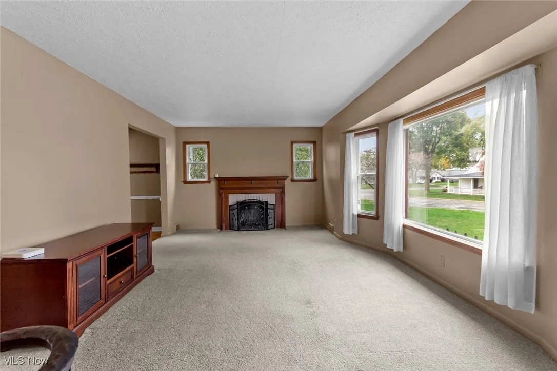Spacious living room with large picture windows and fireplace. Tons of natural light!