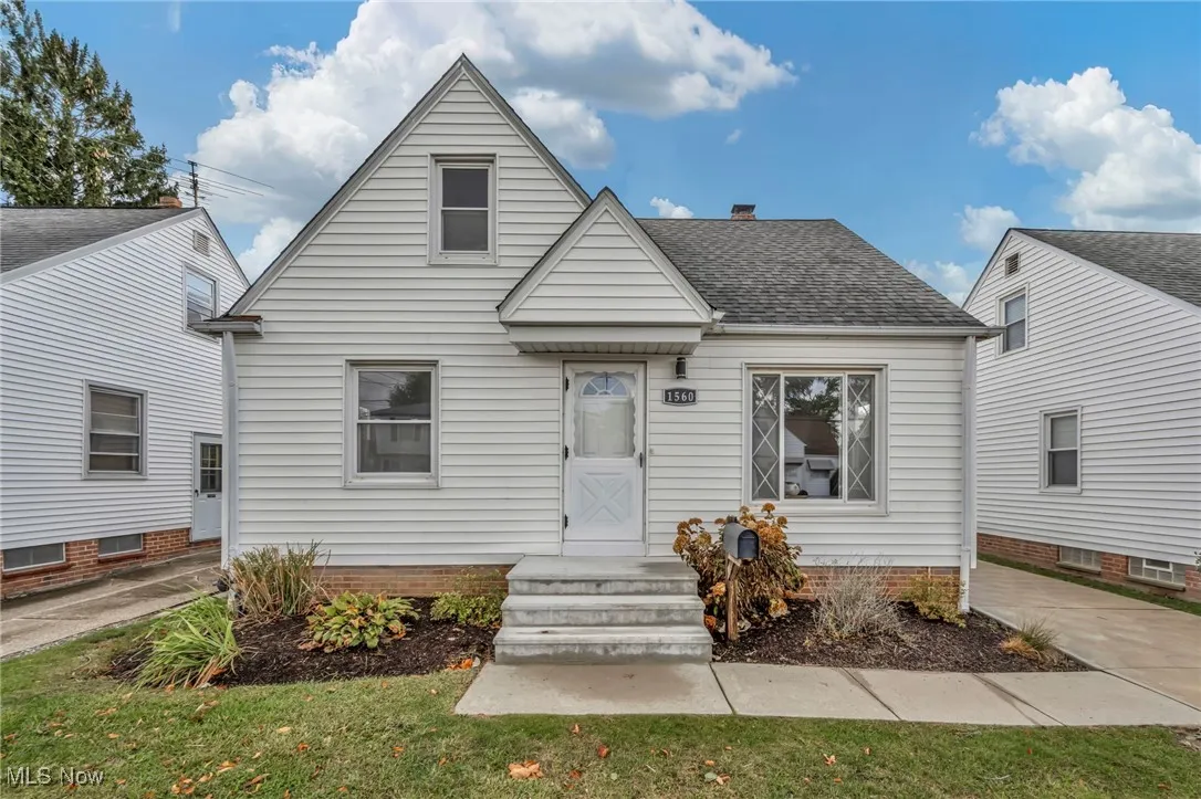 Bungalow-style house with roof with shingles, a chimney, and a front lawn