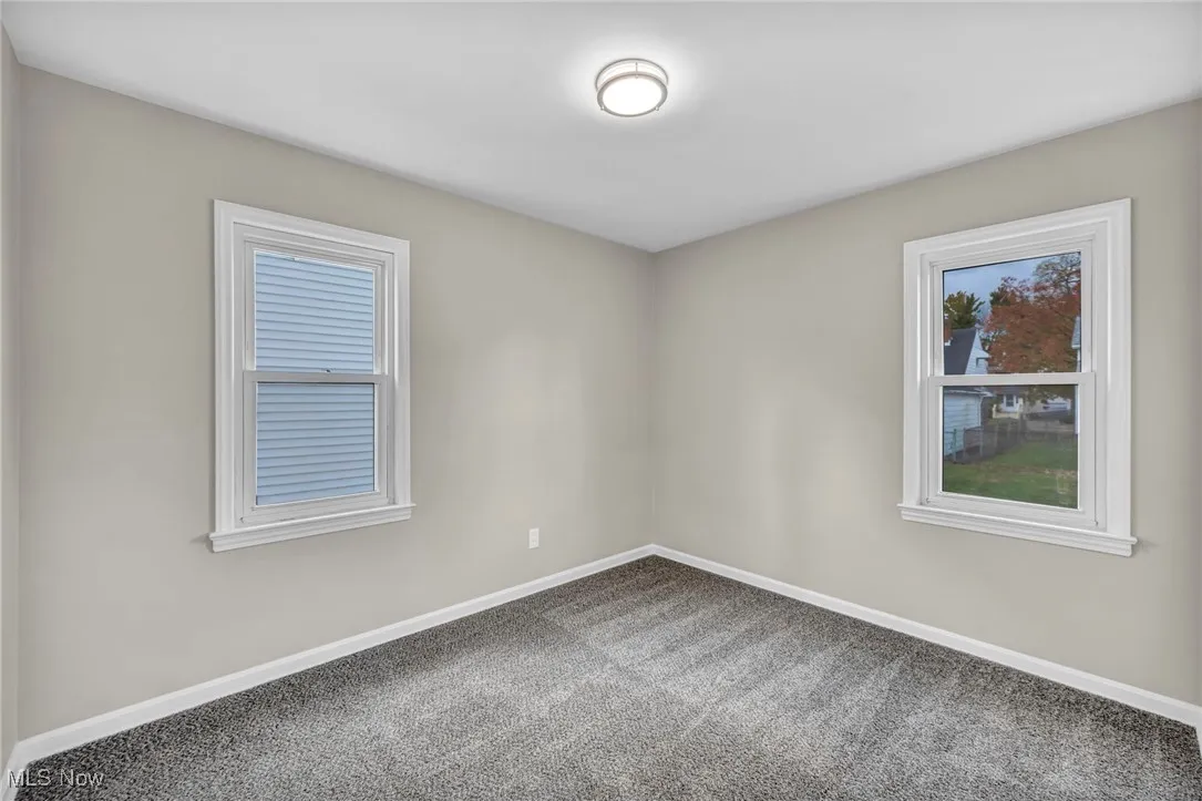 Empty room featuring baseboards and carpet floors