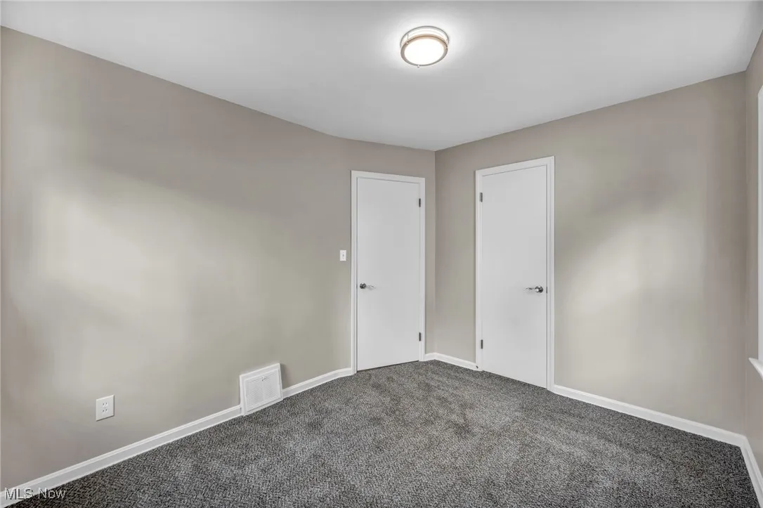 Unfurnished room featuring carpet floors and baseboards