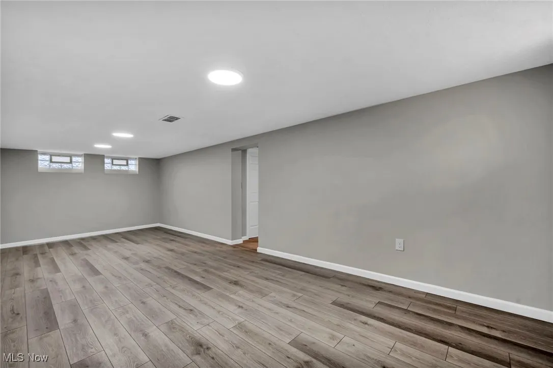 Basement featuring baseboards and light wood-type flooring