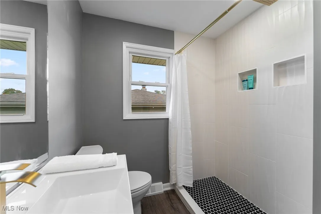 Bathroom featuring a stall shower and vinyl flooring