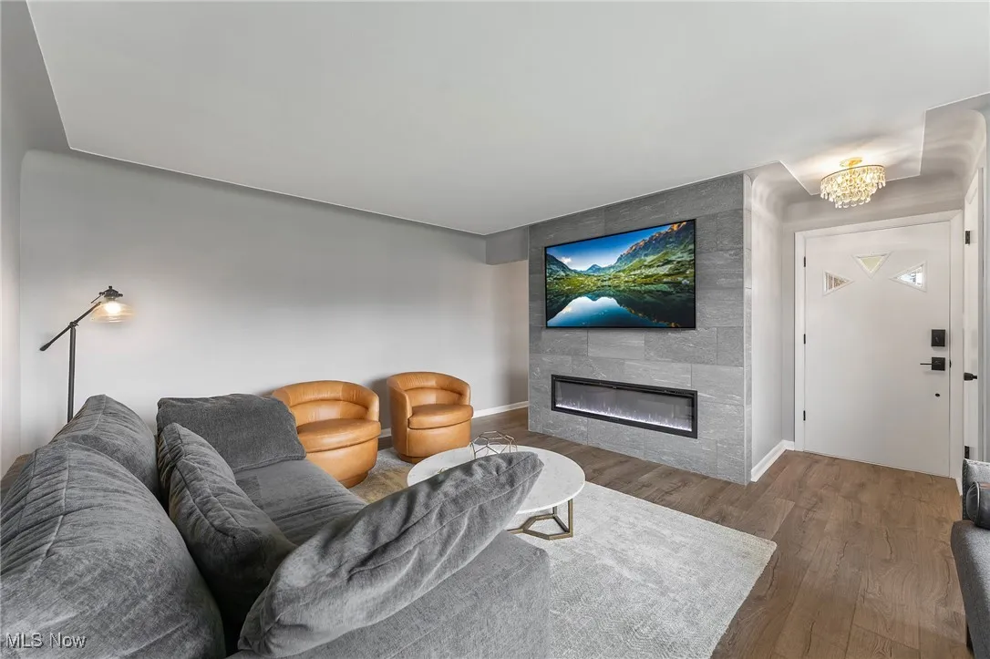 Living area featuring a fireplace, wood finished floors, and a chandelier