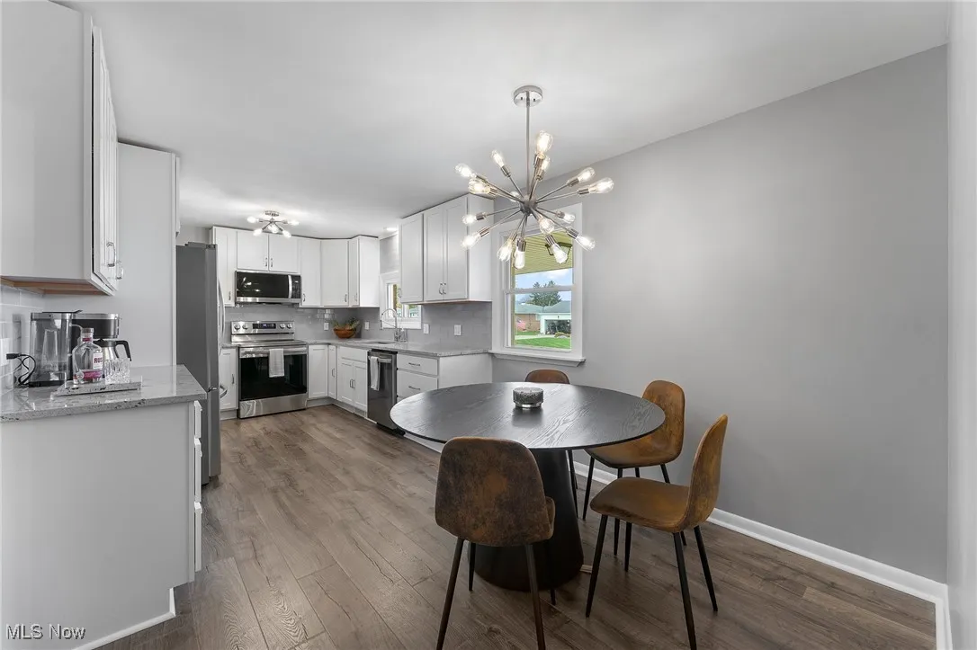 Dining area featuring vinyl flooring and a chandelier